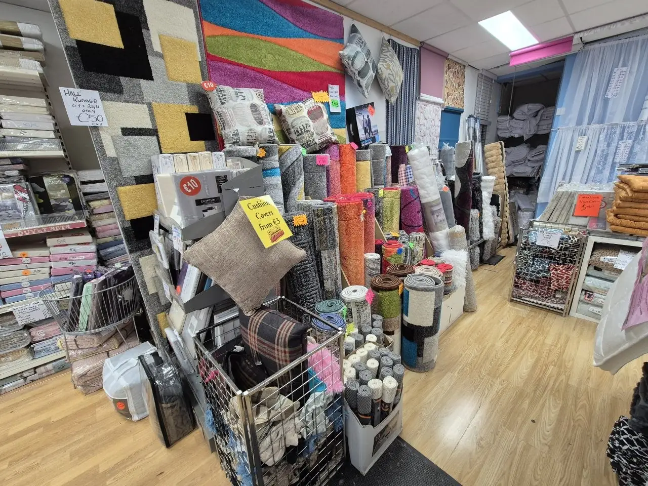 Rugs stood on end at the back of the shop